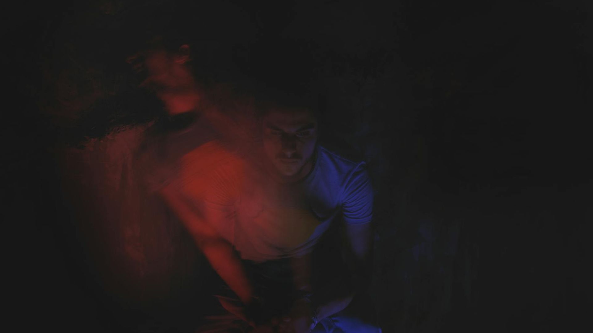 Silhouette of a person in a dynamic pose against a dark, atmospheric background.